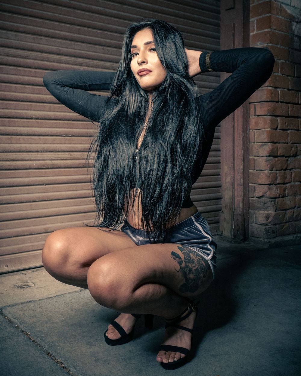 Urban fashion portrait featuring long dark hair and casual street style.