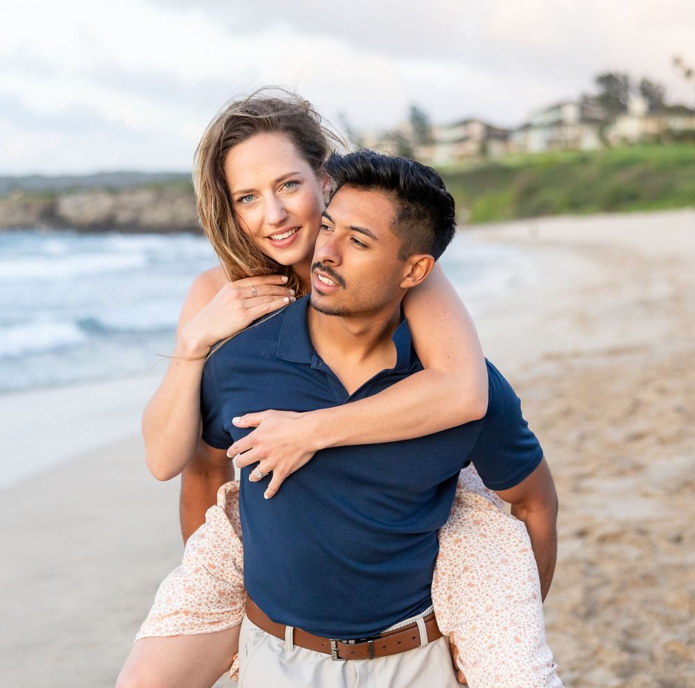 Beautiful couple piggybacking on the beaches of Kaanapali during a surprise engagement.