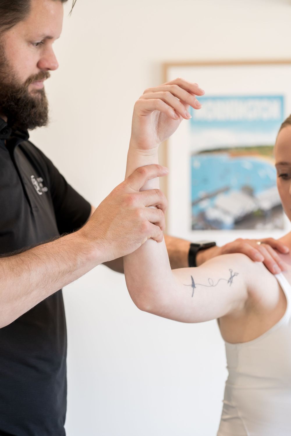 Therapist examining patient's arm mobility during rehabilitation session.