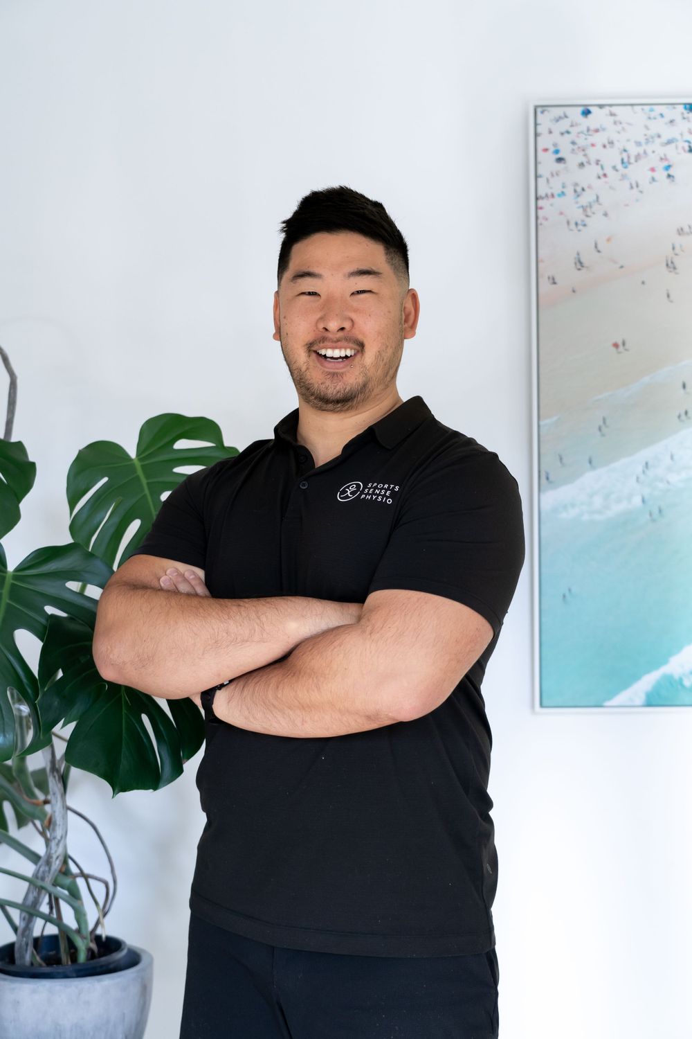 Healthcare professional in black uniform poses confidently in modern medical office.