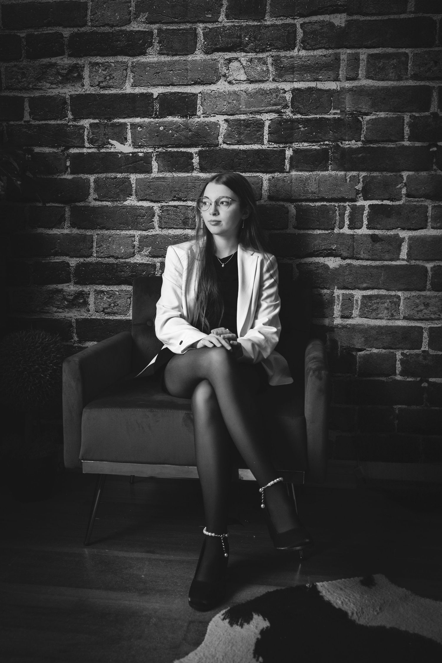 Dramatic black and white portrait series against a brick wall backdrop.