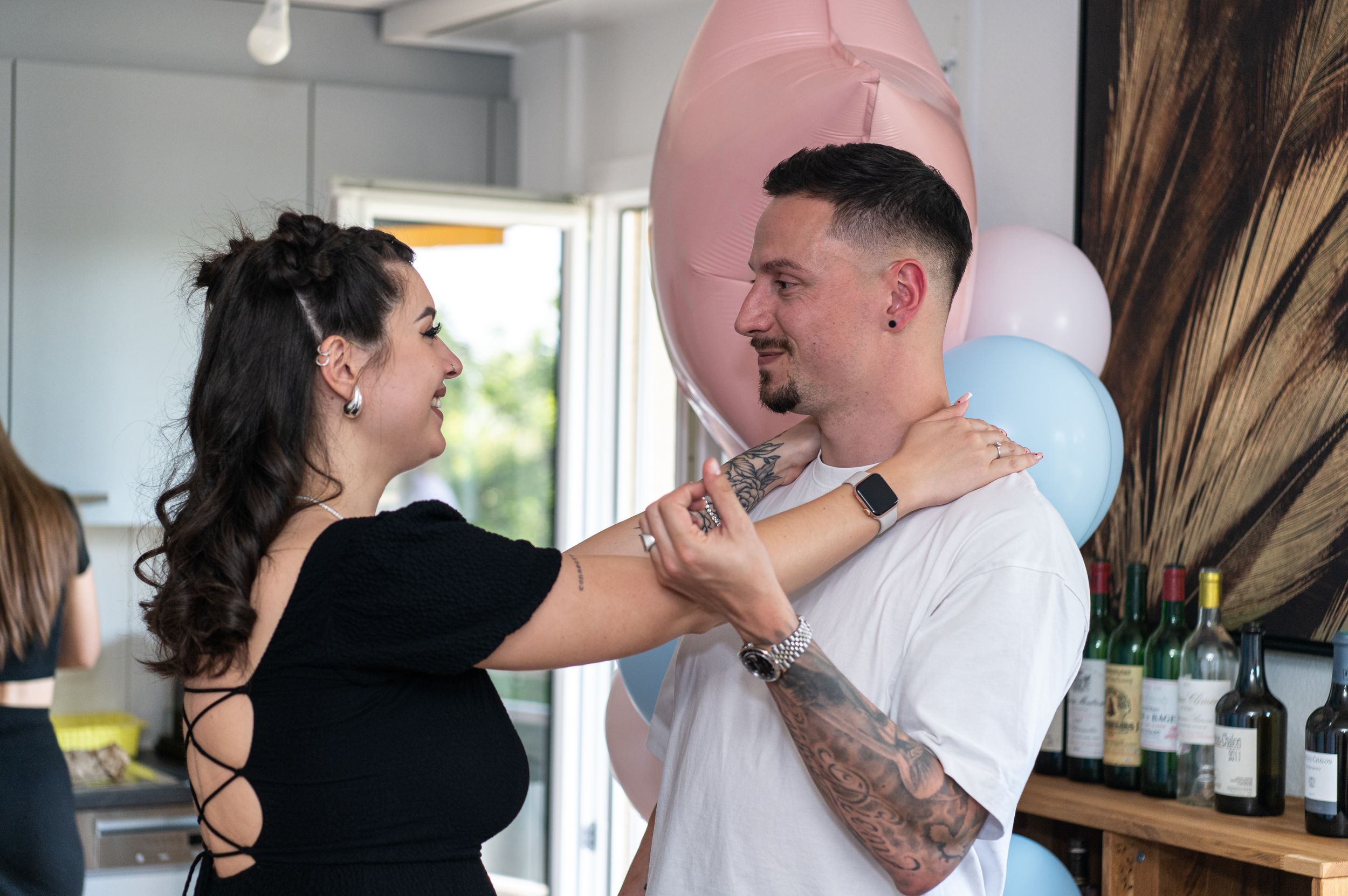 Emotional reactions during gender reveal party with blue and pink decorations.