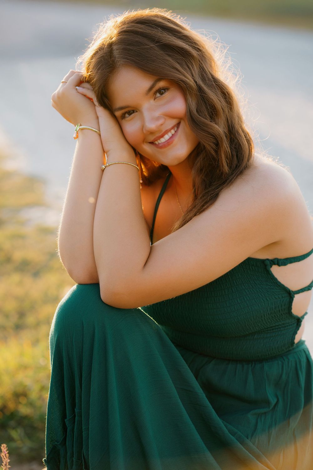 A person in a dark green dress poses outdoors during golden hour in a series of connected artistic portrait shots.