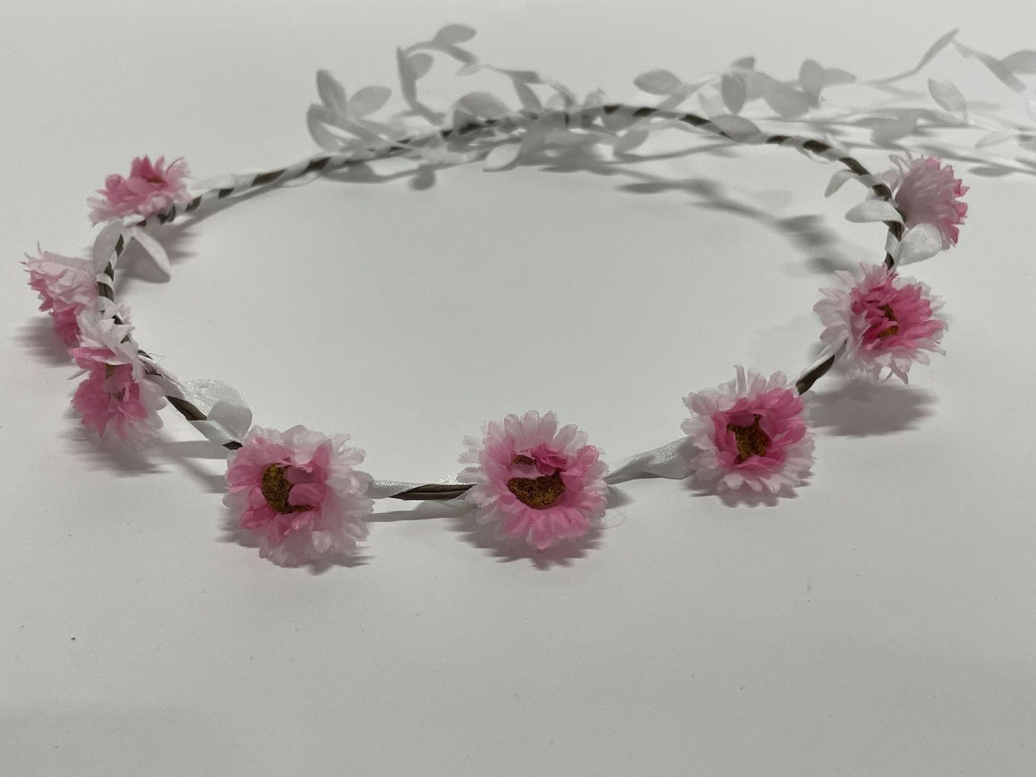 Dainty flower crown with pink daisies spaced evenly around a wire frame.