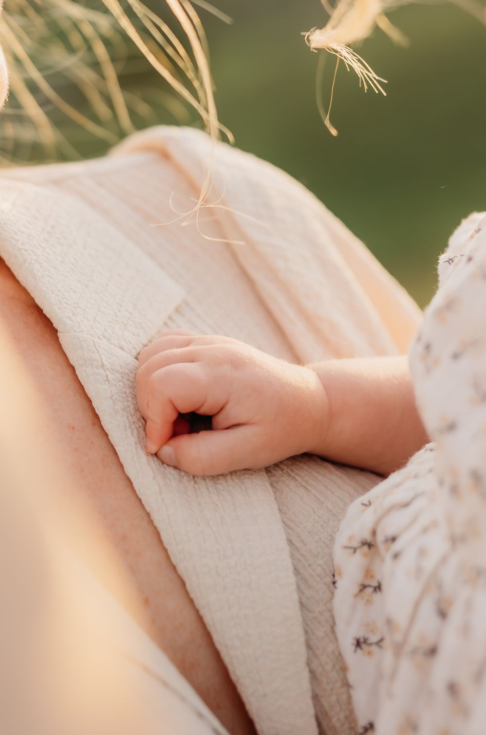 A hand on mum while they sit at the field during their family session while on holiday in the sunshine coast.