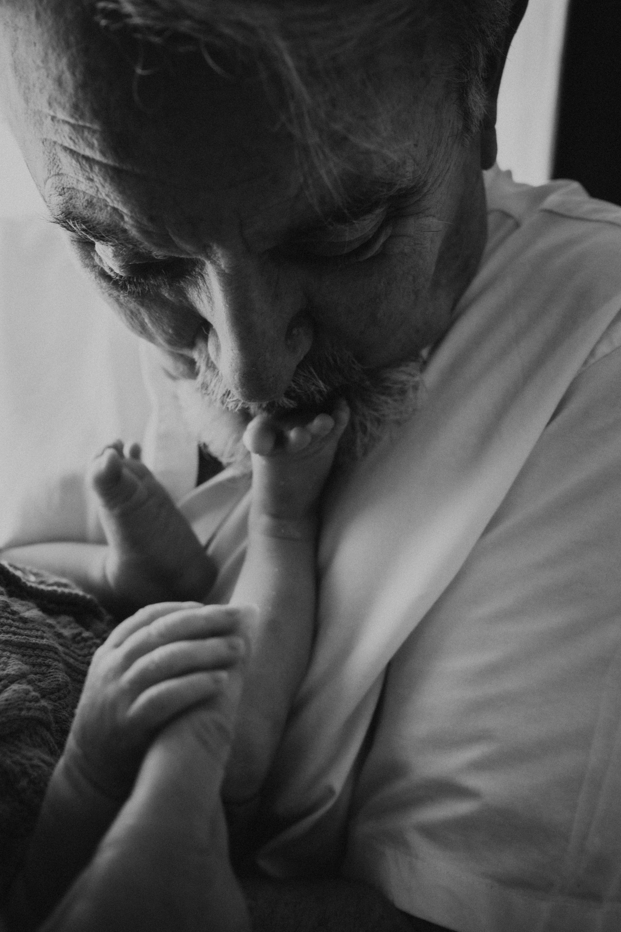 Intimate black and white portrait of tender moment with sleeping infant.