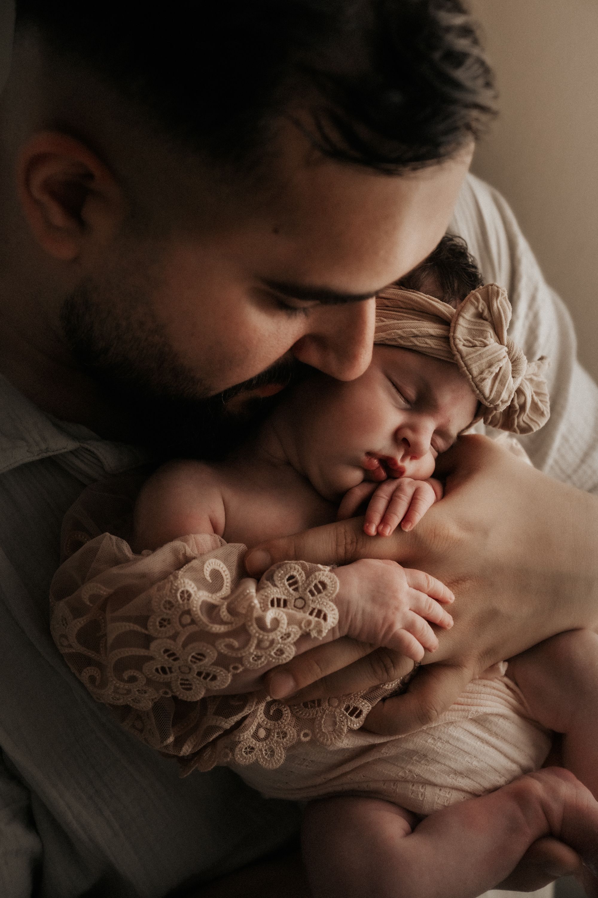 An intimate newborn portrait showing a gentle moment of connection.