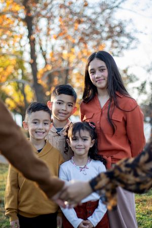 Parents holding hands while the kids are behind them.
