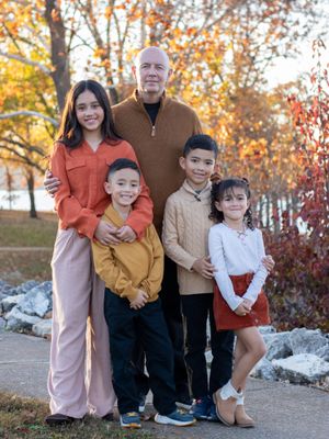 Dad and his kids smiling hugging by the lake.