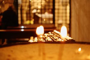 Close-up of burning candles on a dark surface creating a warm atmospheric glow.
