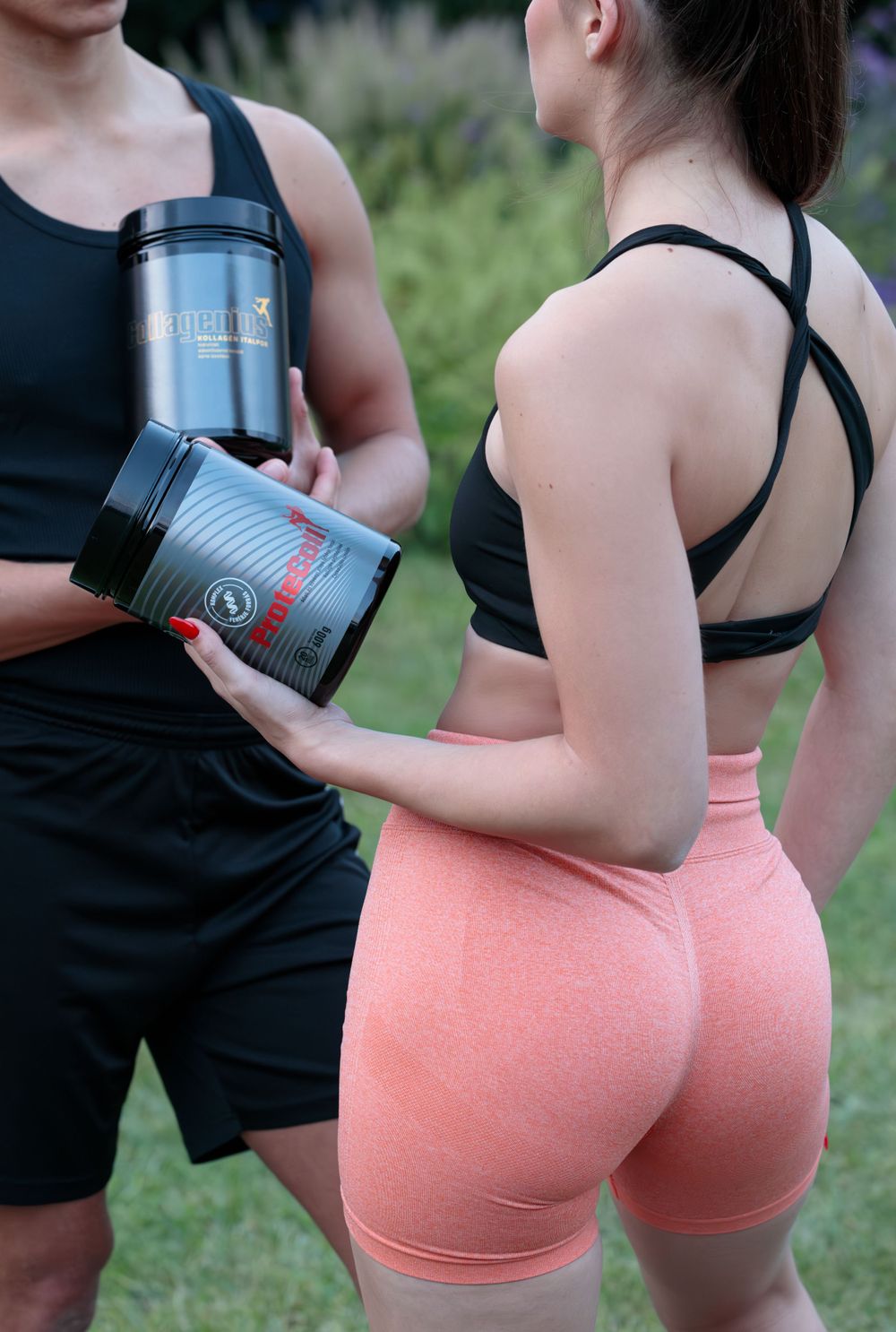 Athletes in workout gear holding black supplement containers during outdoor fitness session.