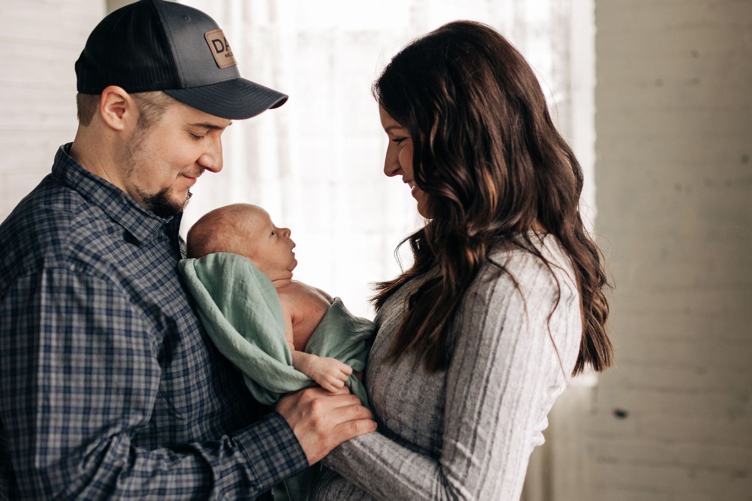 A heartwarming family scene captured against a bright window backdrop.