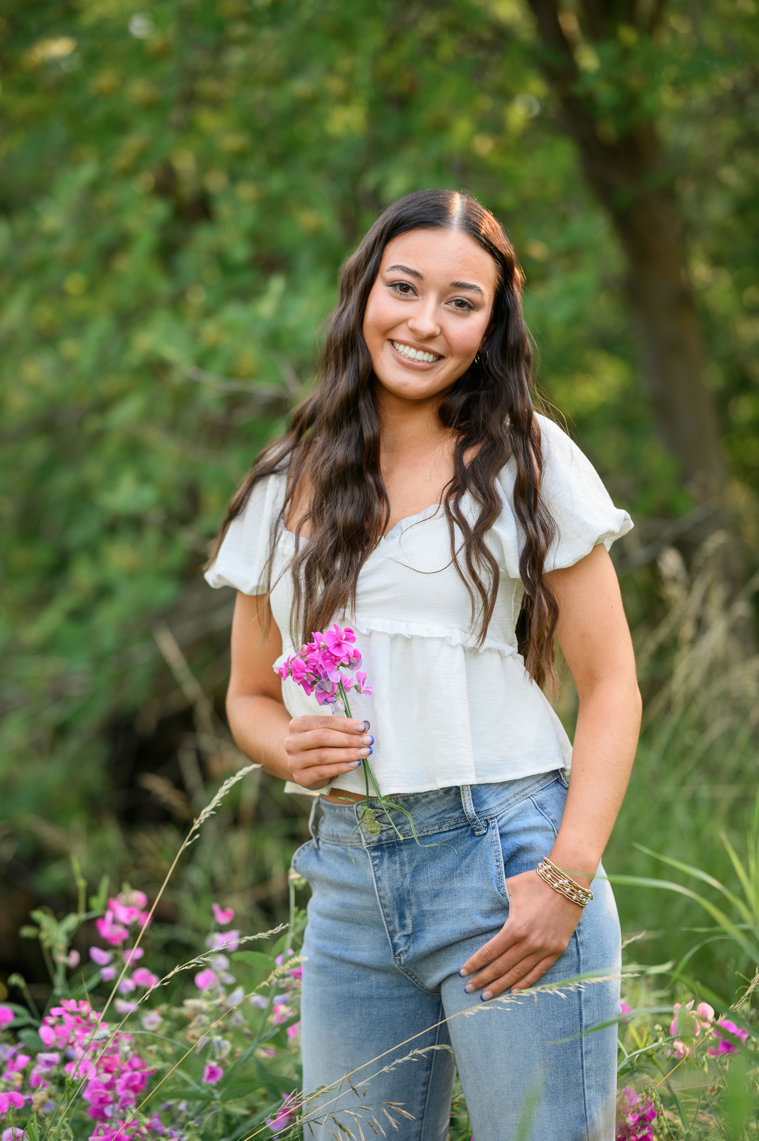 Summer garden portrait with pink flowers wearing white top and distressed jeans. Wallowa Lake, Joseph, Oregon