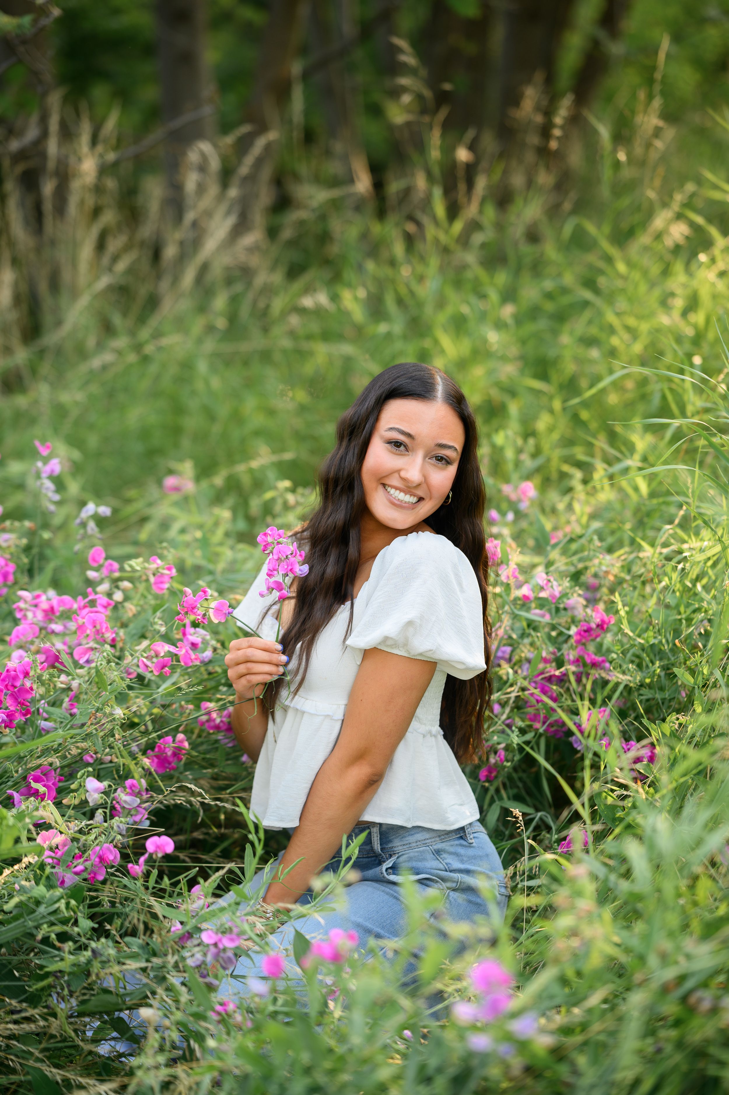 Candid moment in flower garden wearing white blouse and jeans. Wallowa Lake, Joseph, Oregon