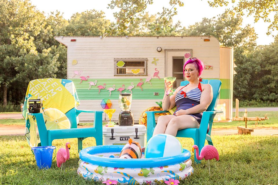 Summer scene with inflatable pool and colorful decorations outside vintage camper.