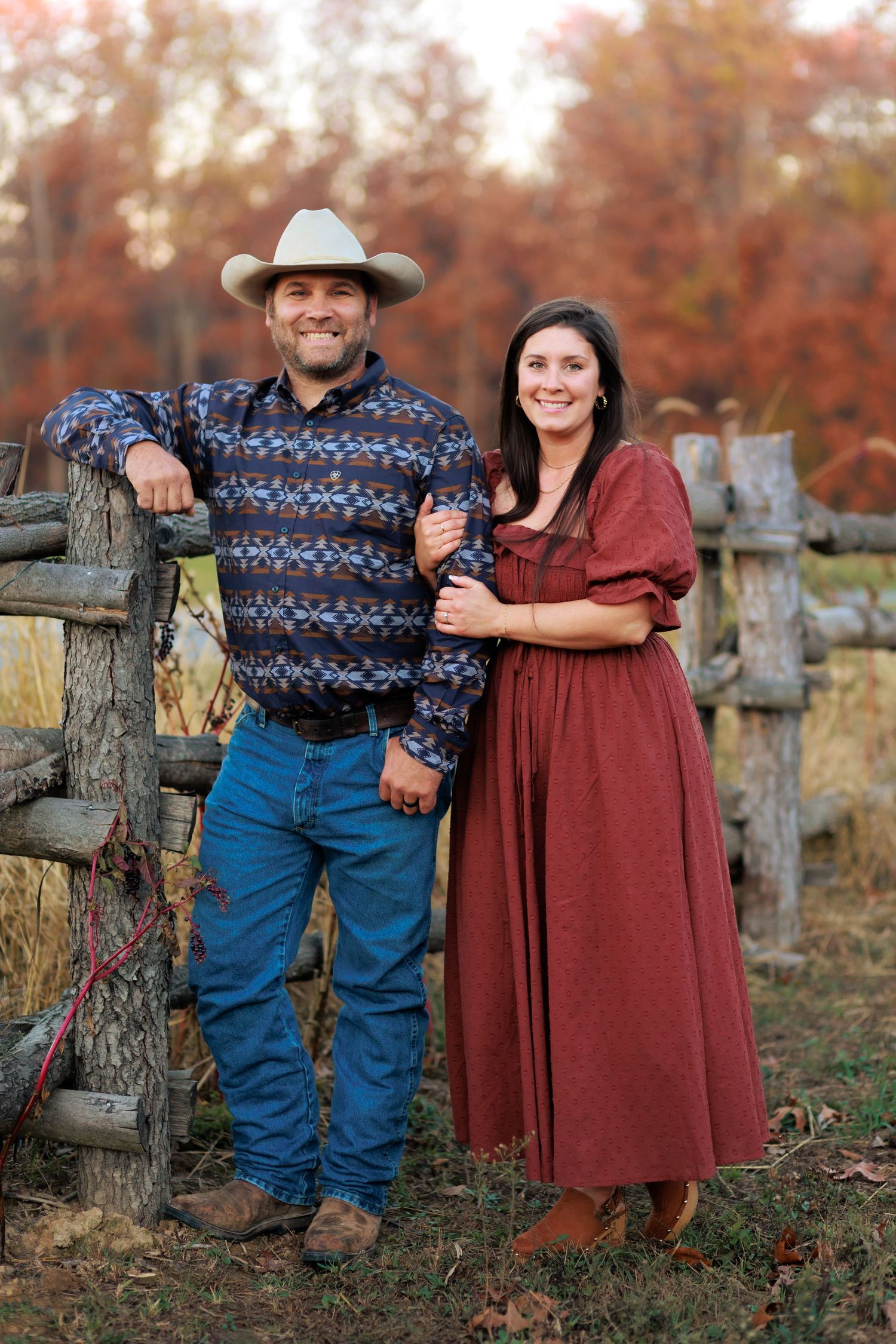 Country western couple with hand-made wooden fence in the background. Located on the old Helm's Tree Farm outside of Neoga, Illinois.