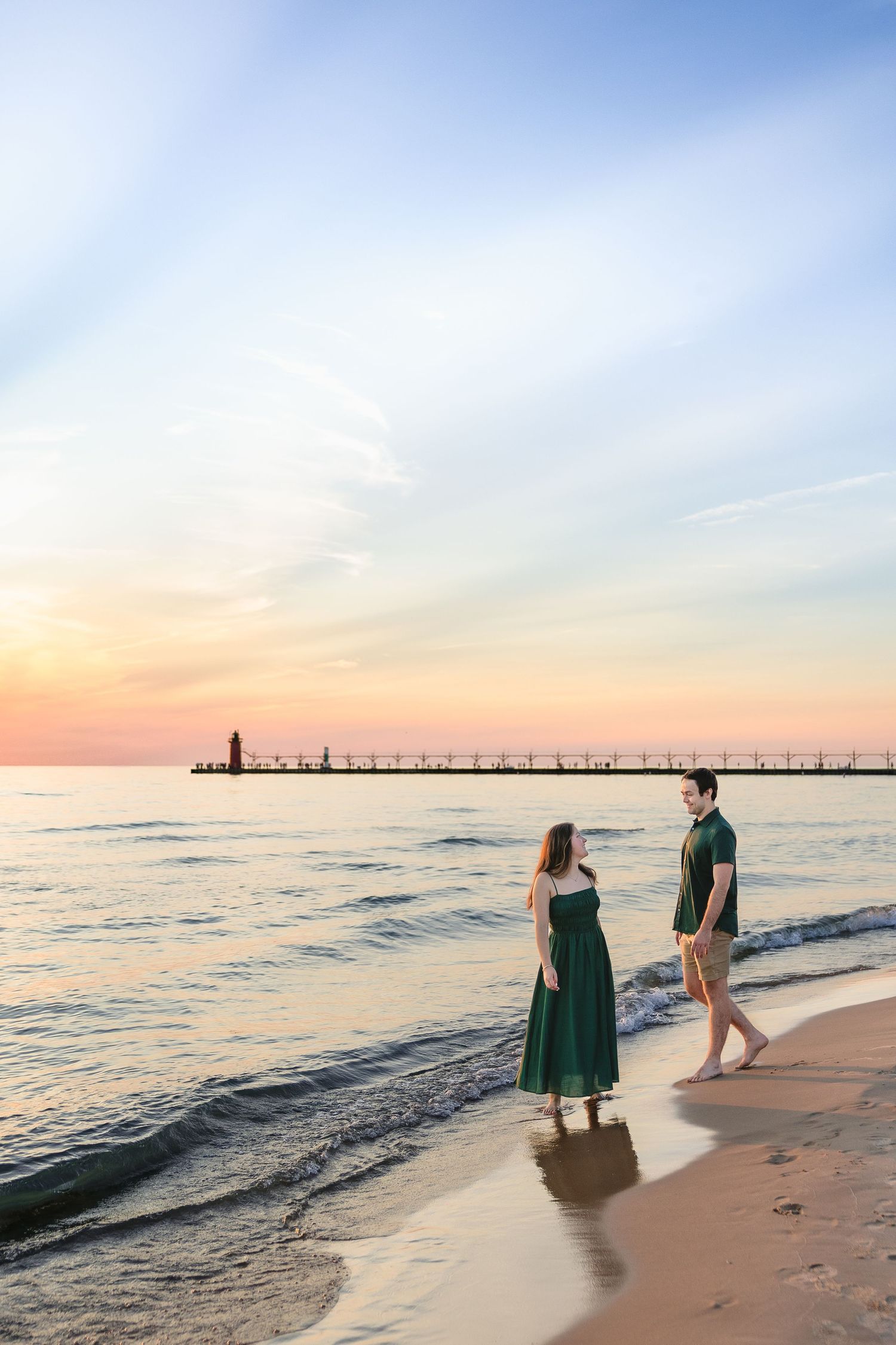 Photo of a couple at sunset, admiring the lifeguard stand and one another.