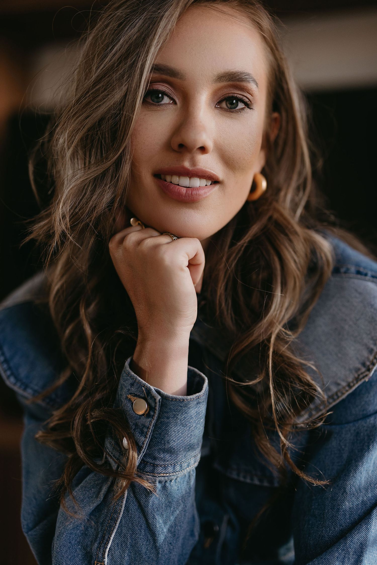 Portrait in denim jacket with soft lighting and warm tones.