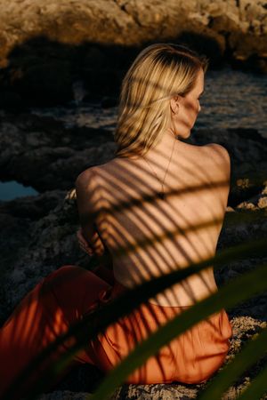 a woman with a palm tree shadow on her back in Port Adriano, Mallorca