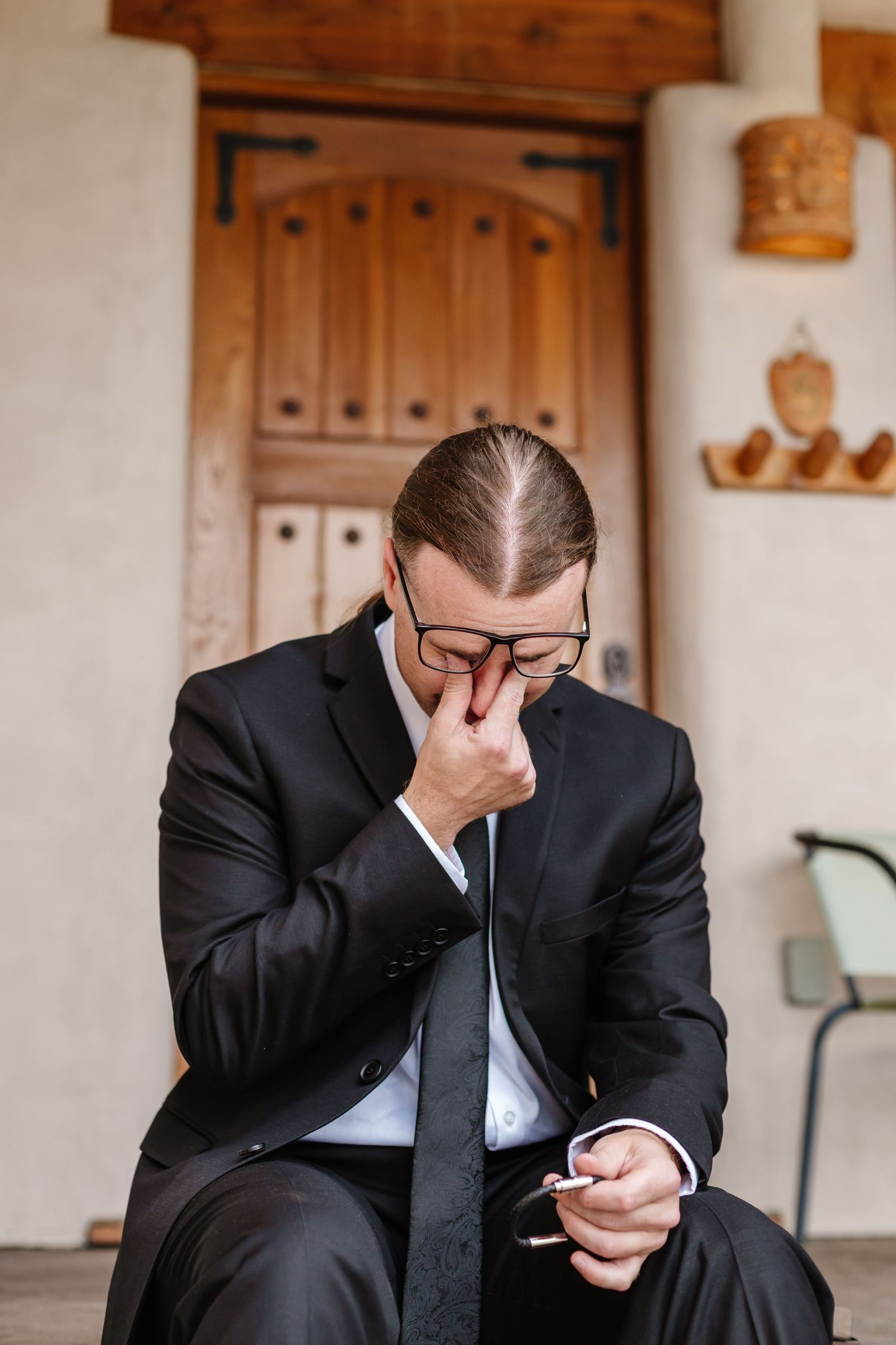 An emotional moment captured during wedding preparations in a rustic indoor setting.