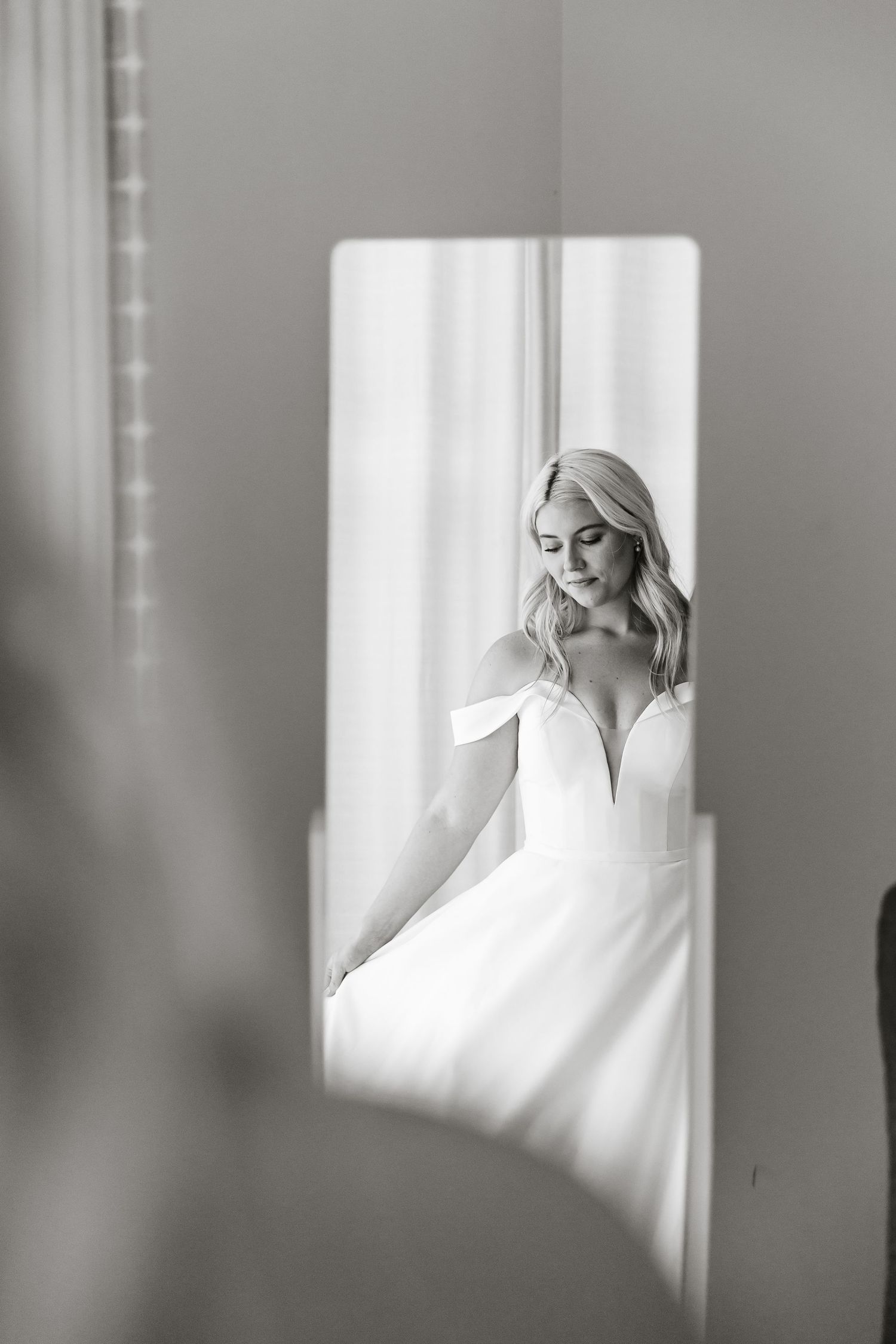 Ethereal portrait in soft monochrome lighting with figure by window creating dreamy atmospheric composition.