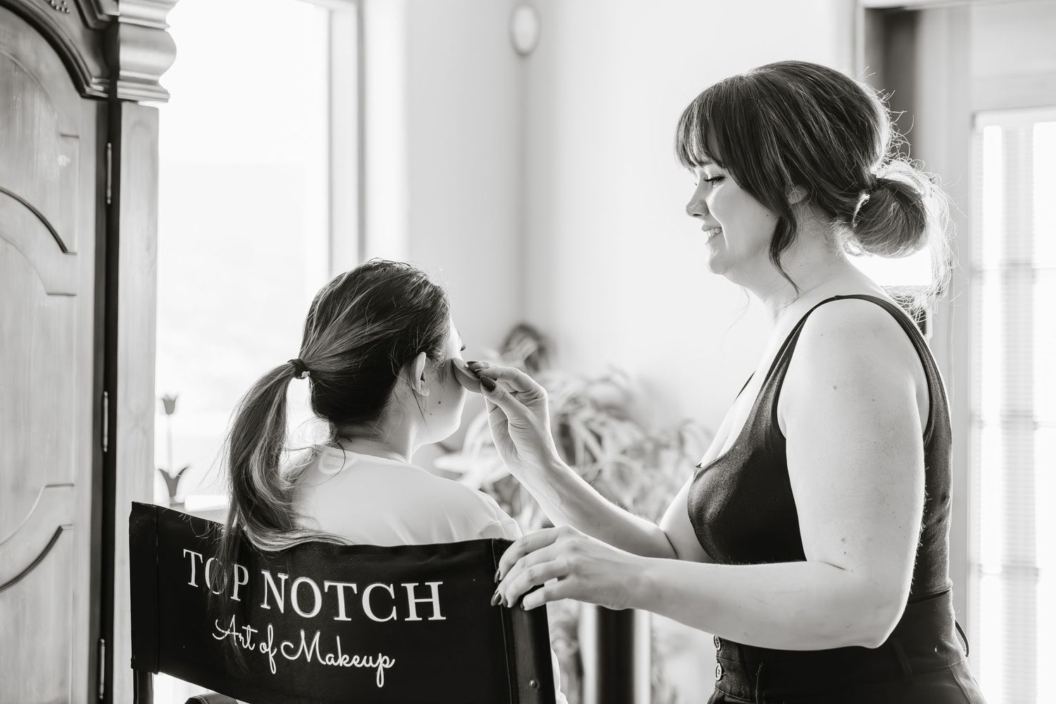 Black and white image of people working together in a beauty salon setting.