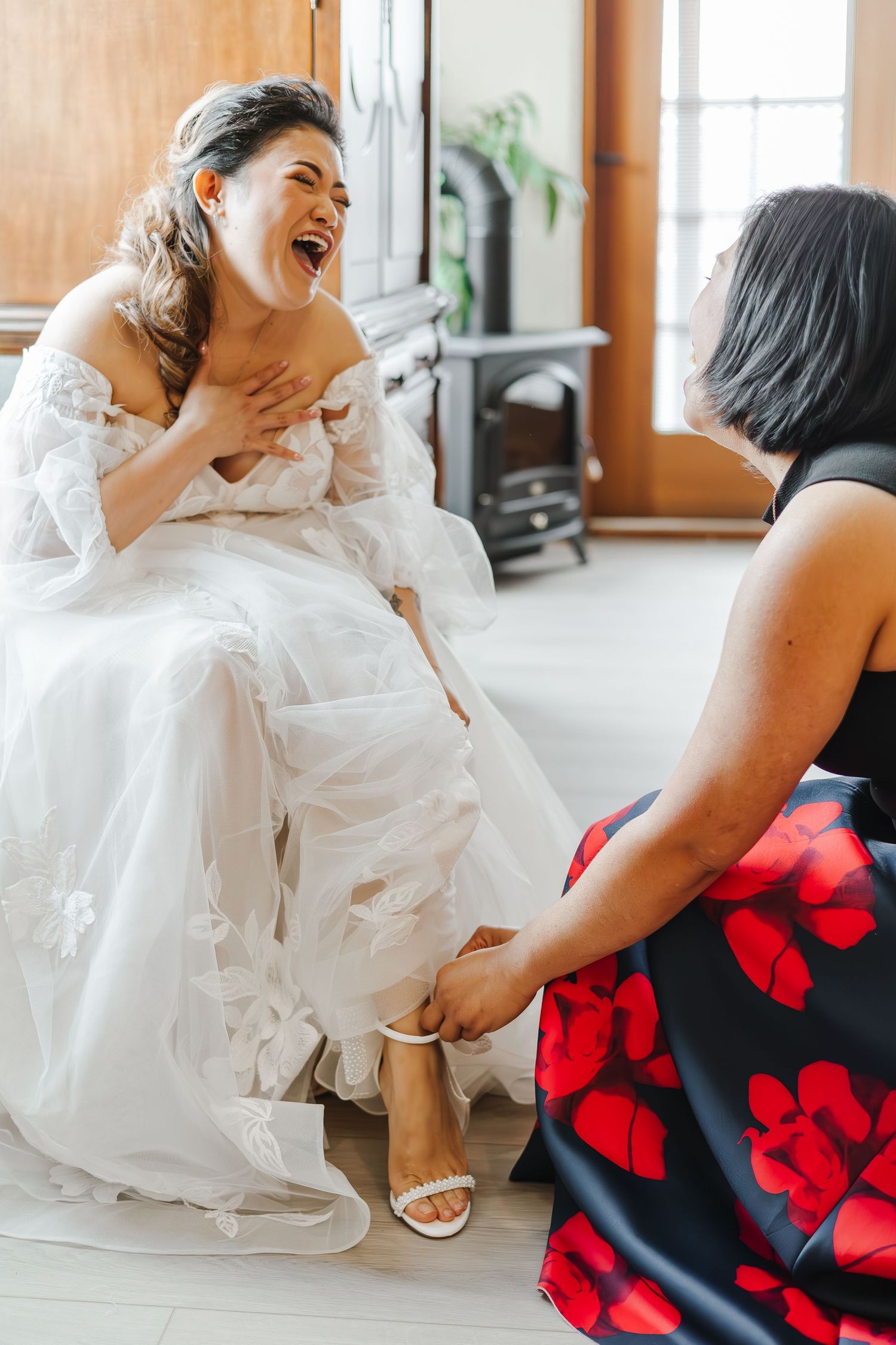 Close-up view of white wedding dress and red floral dress details during a wedding preparation moment.