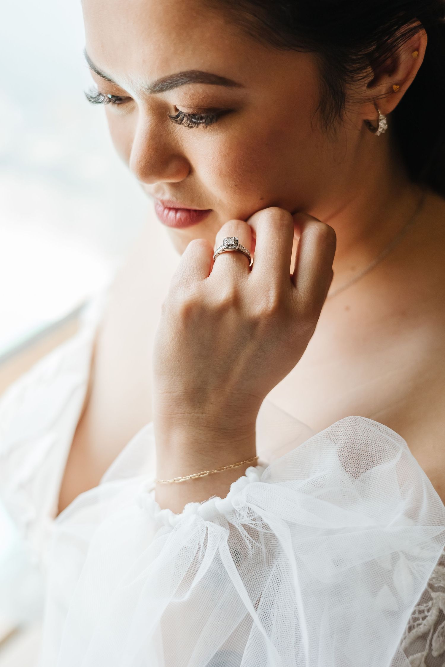Close up shot of bridal jewelry and makeup details with soft natural lighting.