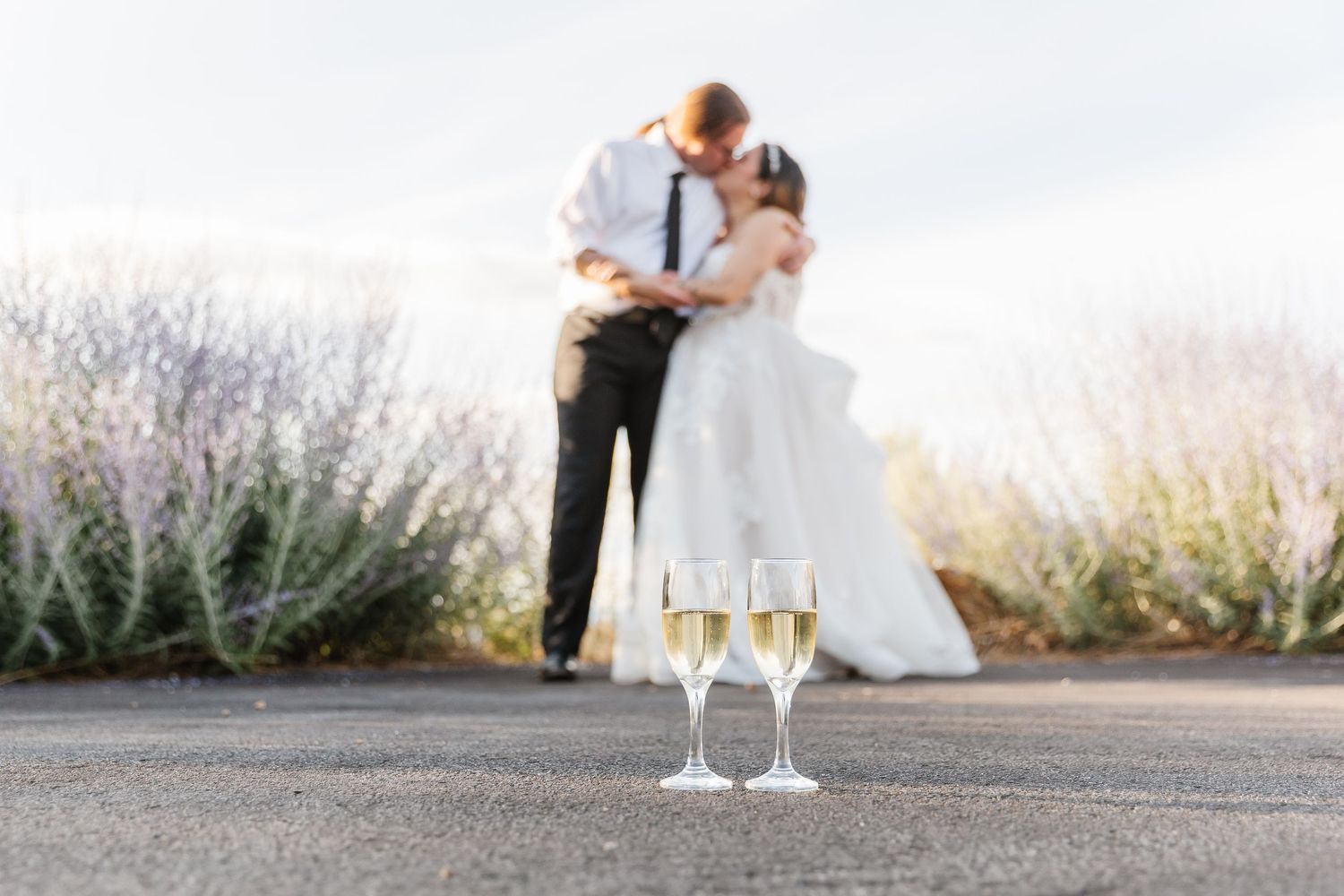Newlyweds share romantic moments with champagne glasses at their mountain wedding celebration.