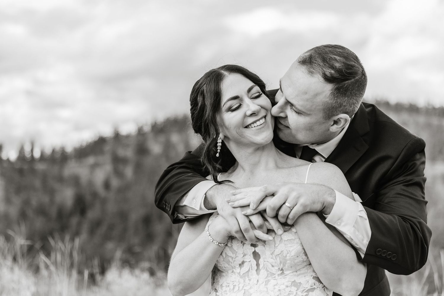 A romantic black and white wedding photo series showing tender moments between newlyweds in an outdoor setting.