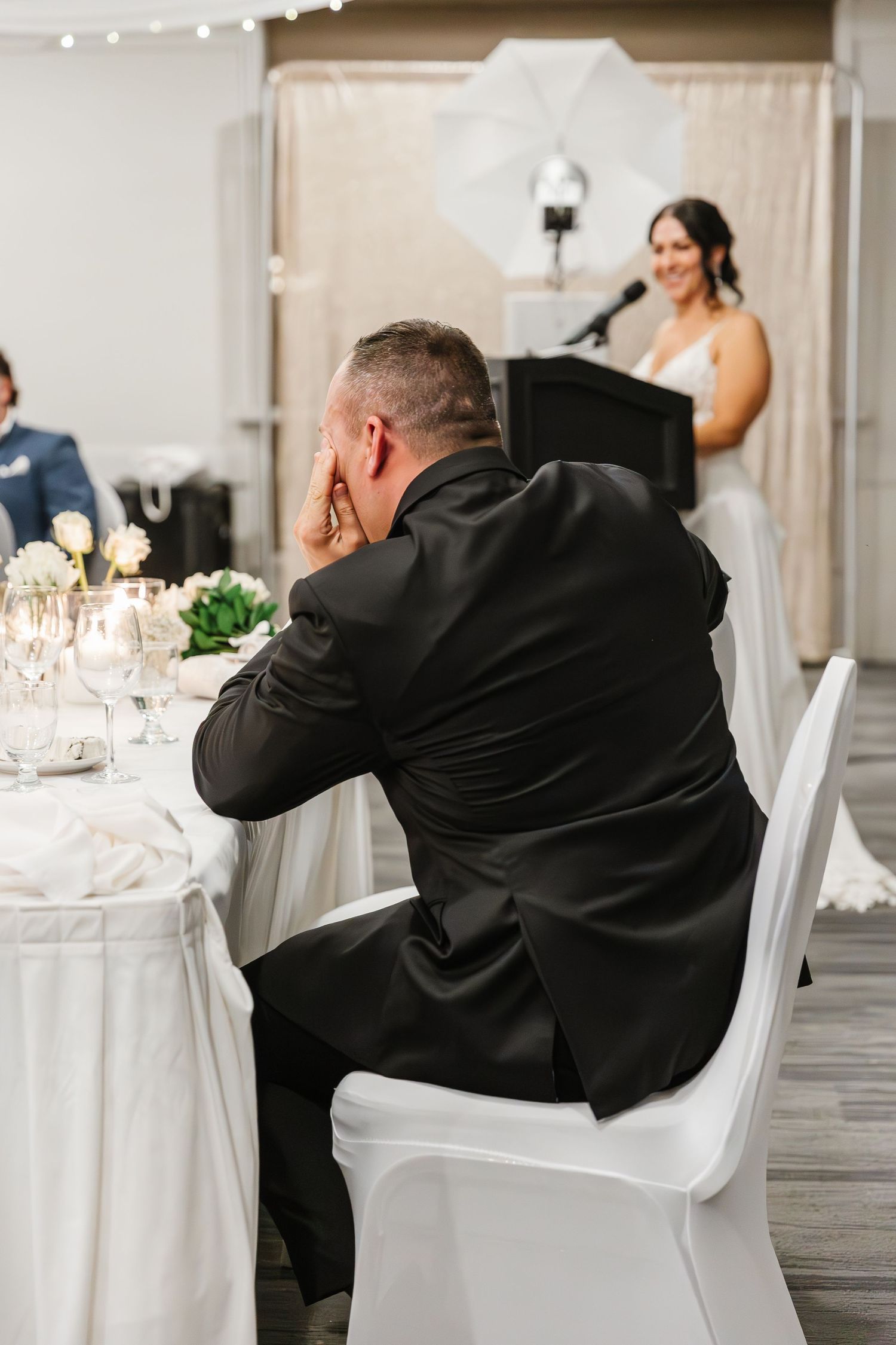 A series of photos showing a person in a black suit sitting at a white-clothed table at a formal event.
