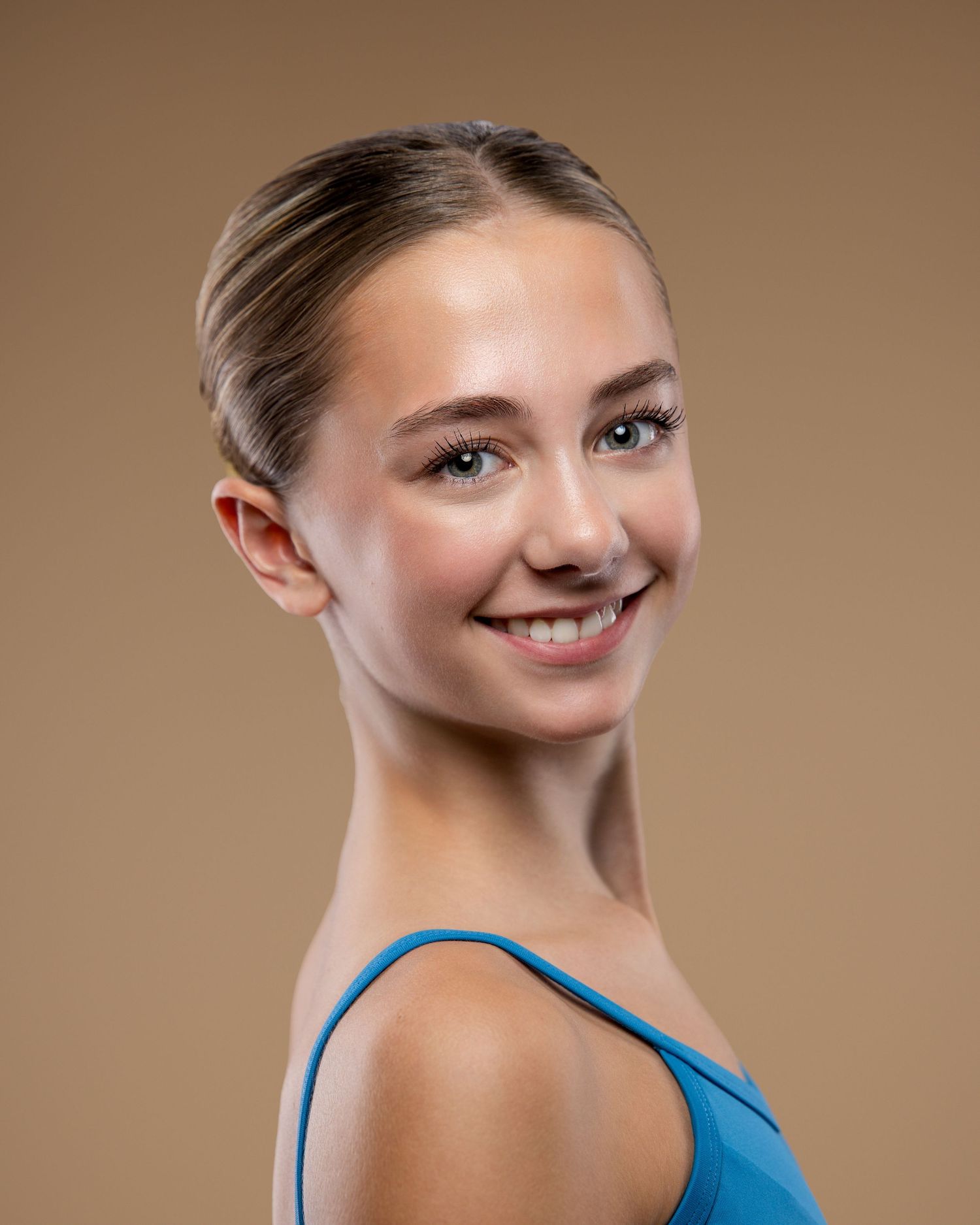 Ballet dancer headshot with hair in a bun.