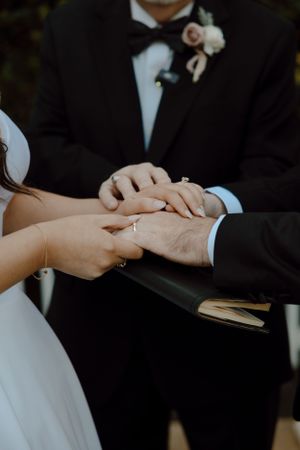 Close-up of hands exchanging rings during wedding ceremony.