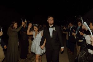 Wedding party celebrating with sparklers during an evening outdoor reception.