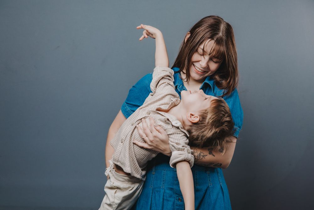 Playful studio portraits showing dynamic movement and interaction in blue and beige outfits.