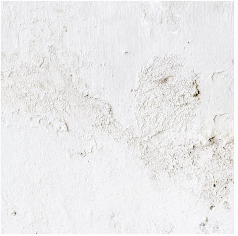Textured white plaster surface with subtle stains and rough finish.