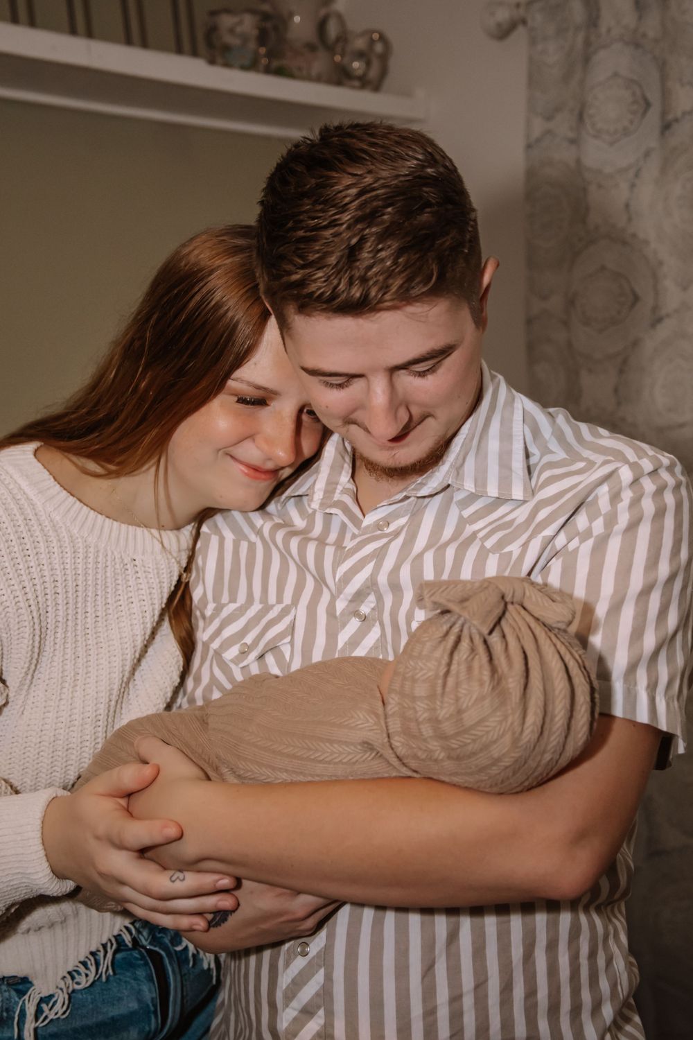 A couple in matching striped and white outfits share tender moments in a series of intimate photographs.