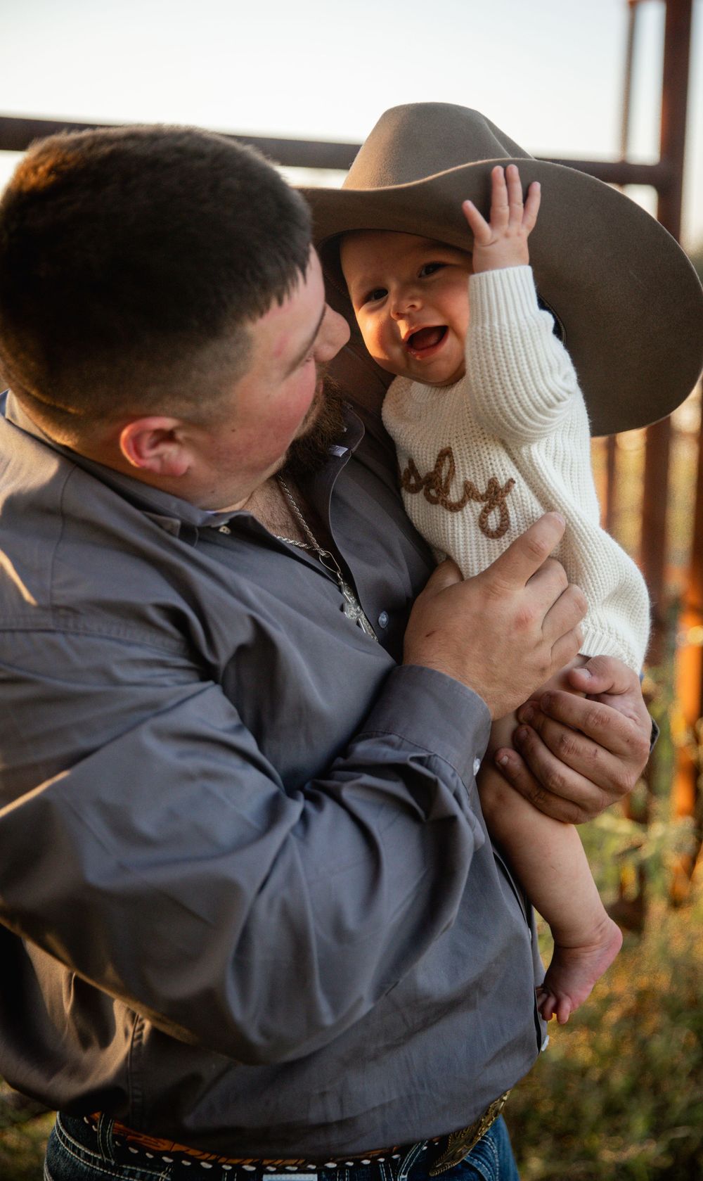 Playful western-themed couple photoshoot with cowboy hats and casual attire at sunset.