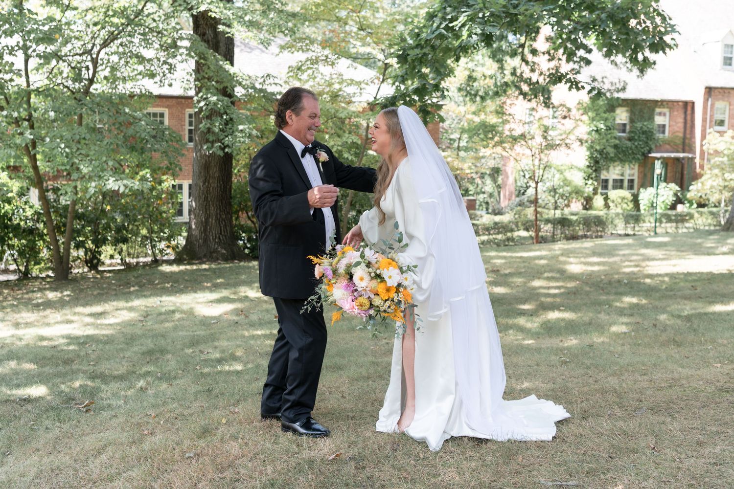 Newlywed couple standing in a garden setting with colorful bouquet.