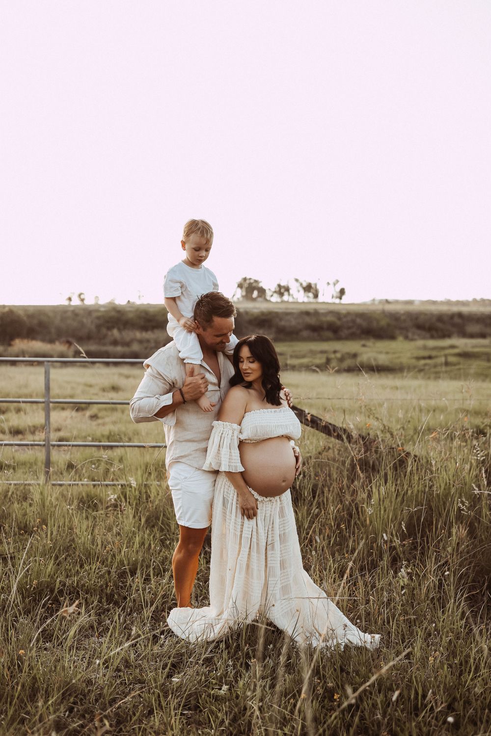 Heartwarming family portrait in rustic field during golden hour.