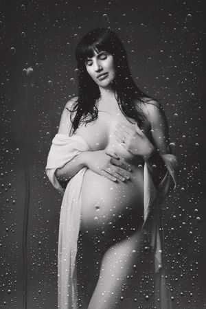 Black and white artistic boudoir photography with sparkle overlay effect shows a figure in flowing fabric.