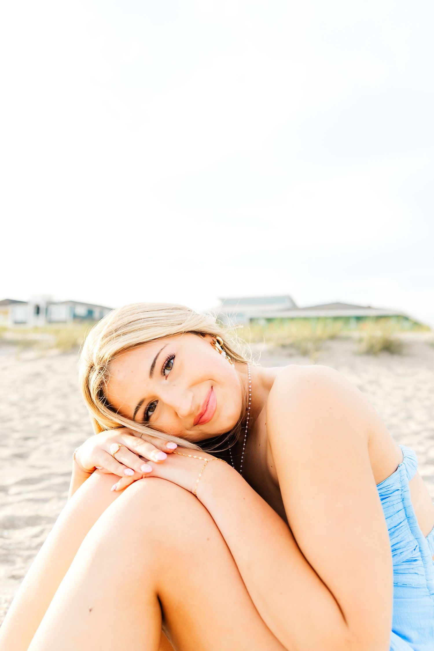 Woman relaxes on sandy beach during sunny summer day. PRESLEY ROSE PHOTOGRAPHY SHALLOTE BRUNSWICK BEACHES HOLDEN BEACH NC SC CHERRY GROVE