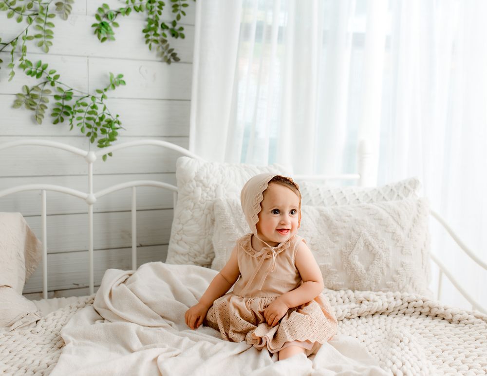 Baby sitting on neutral bed in studio | Pittsburgh luxury child portraits