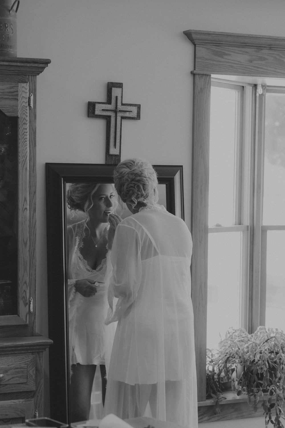 A series of black and white wedding preparation photos showing intimate moments through doorways and windows.
