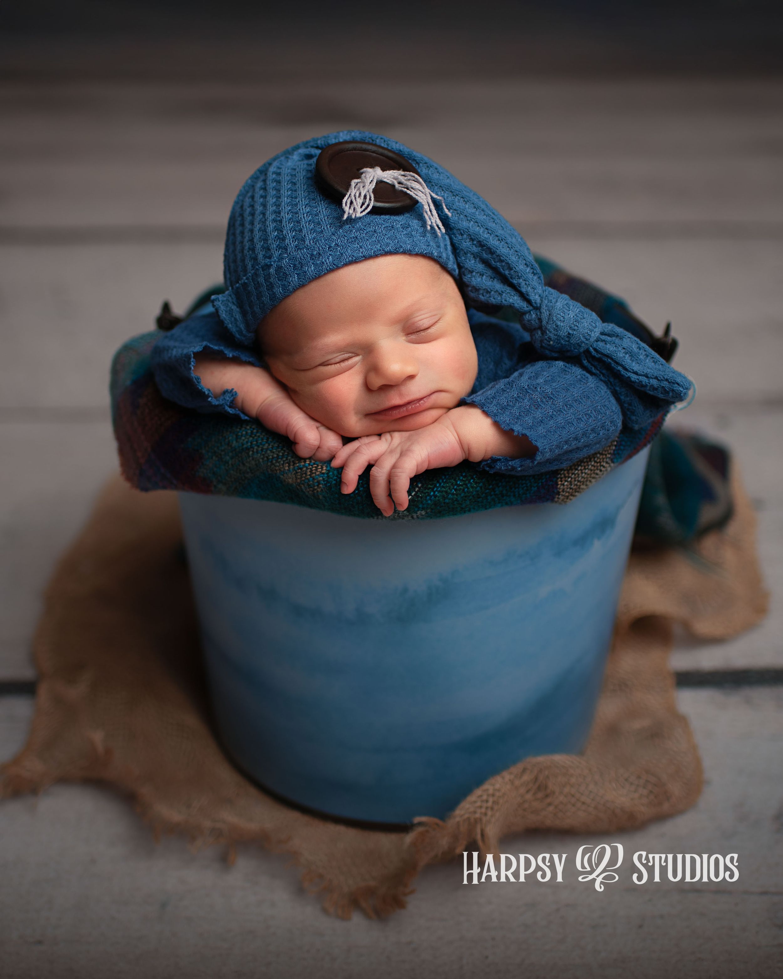 Newborn photographer Lexington, SC; newborn baby boy posed in bucket with sleepy hat; Best professional photographer in South Carolina
