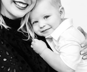 Black and white close-up portrait of parent and baby sharing a tender moment.