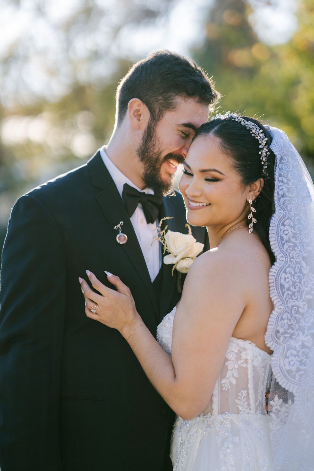 Romantic wedding couple shares intimate moments in soft natural lighting with bride wearing lace veil.