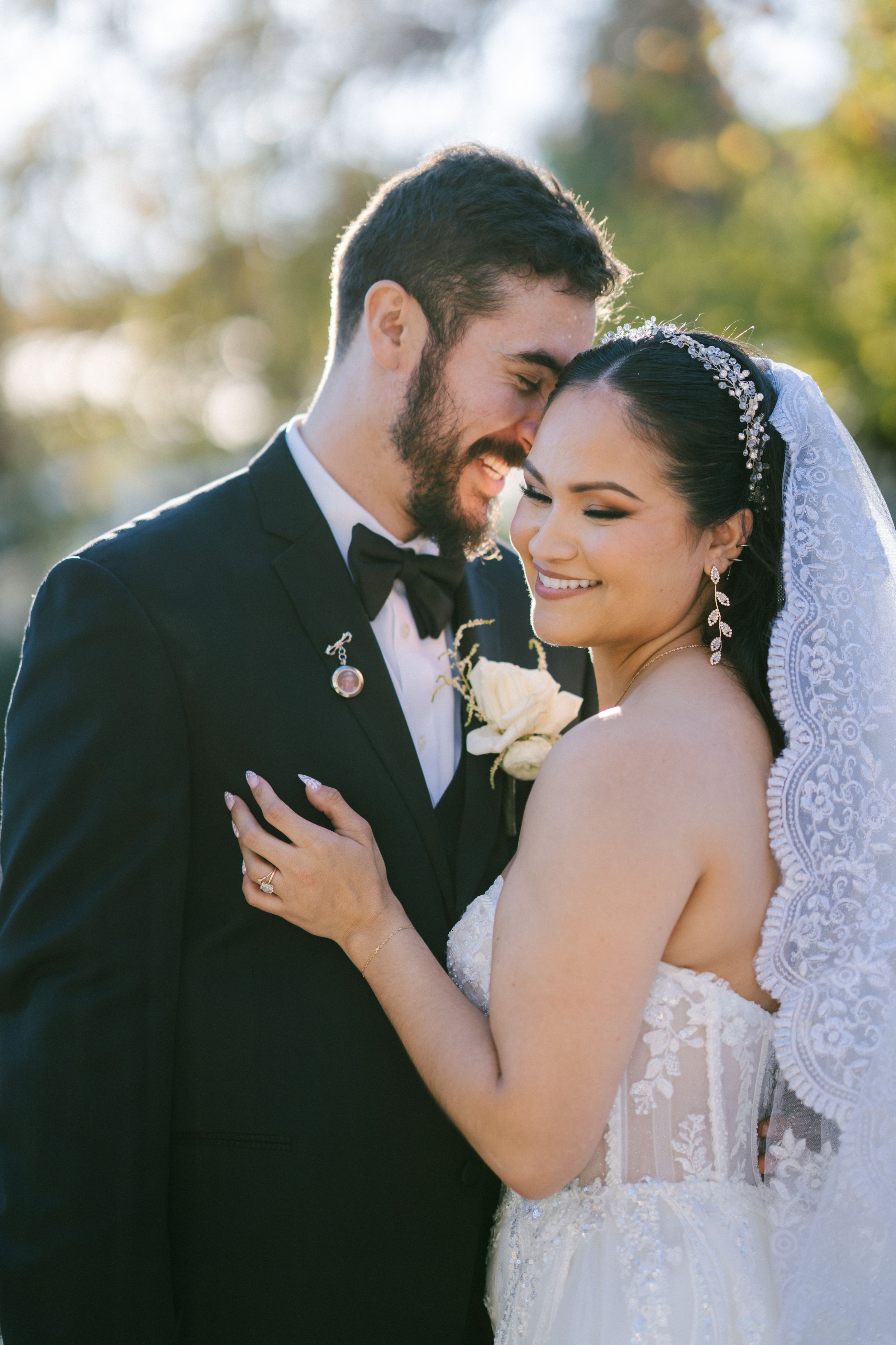 Romantic wedding couple shares intimate moments in soft natural lighting with bride wearing lace veil.