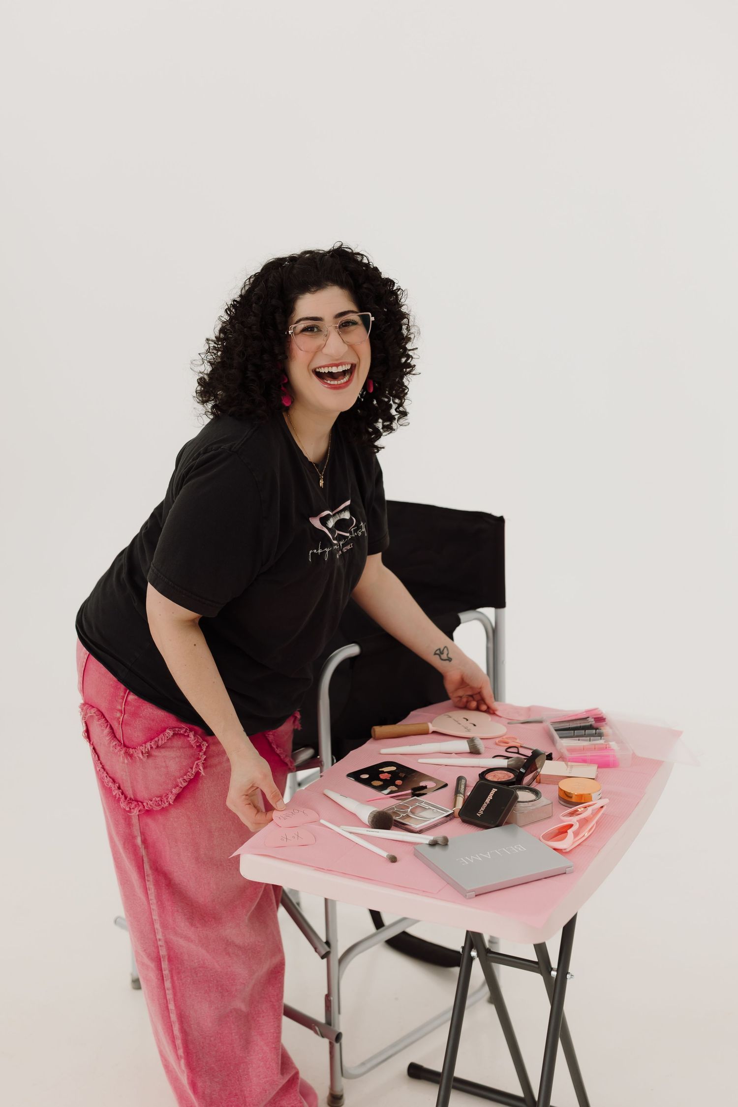 a makeup artist with her set up on a table of all the makeup