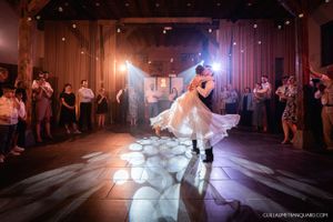 First dance captured in dramatic lighting with smoke effects on a dark dance floor.